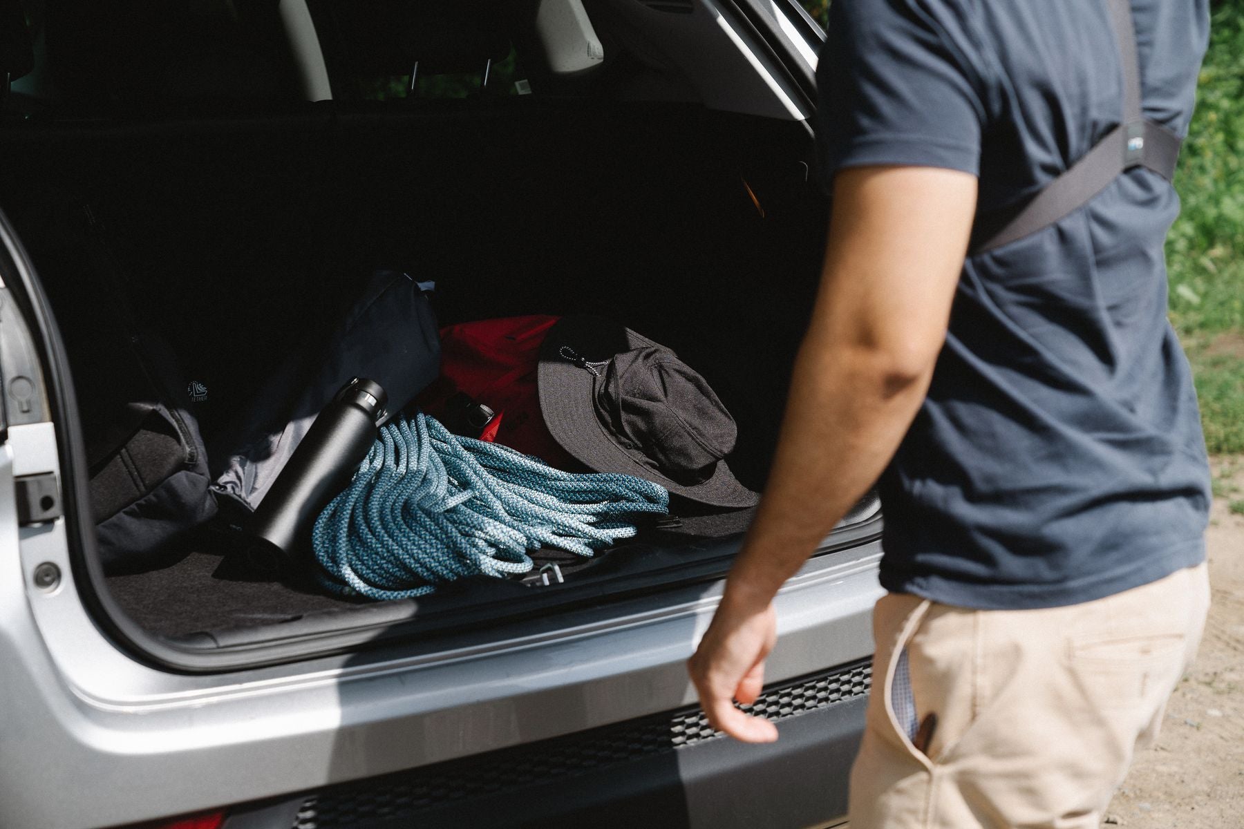 Driver loading automotive accessories into an open vehicle trunk